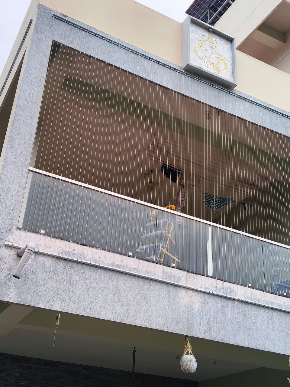 Close view of invisible grill stainless steel cables across a glass-railed balcony