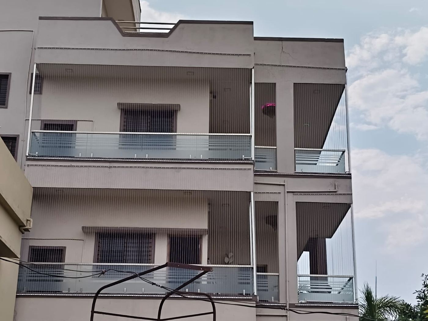 Front elevation of a home with invisible grills across both balcony levels