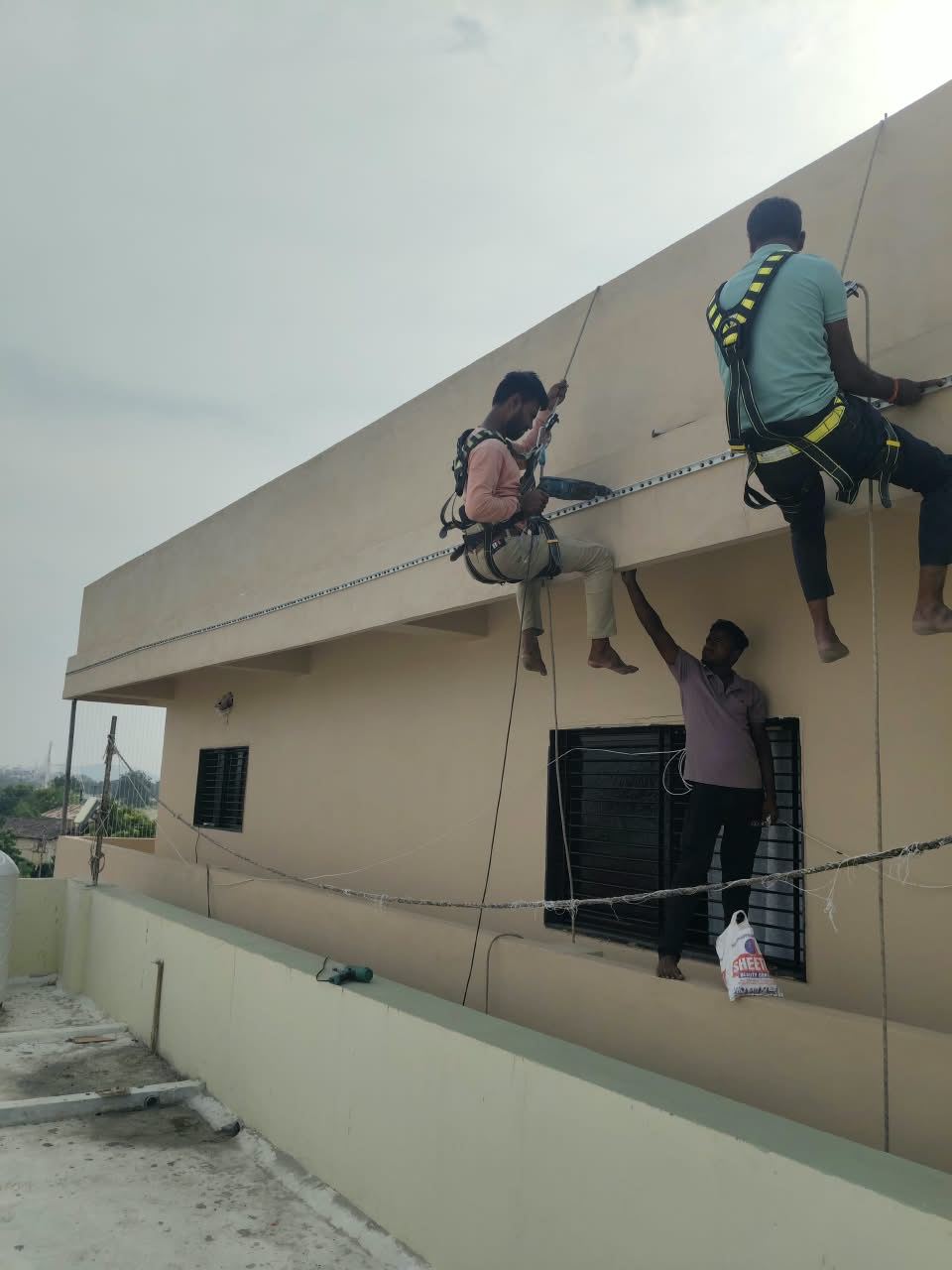 Our installers in safety harnesses fixing invisible grill track