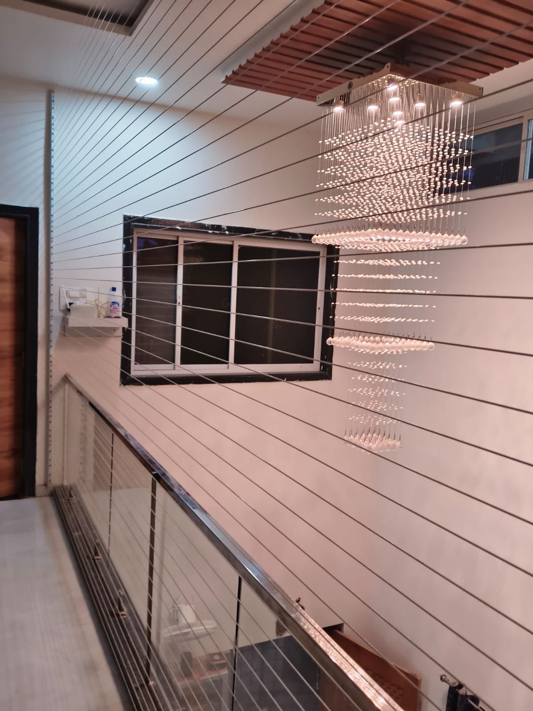 Invisible grill cables closing a double-height staircase opening inside a home